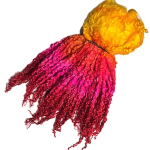 Puede incluir: Un paquete de vellón de merino rizado teñido a mano en tonos de rojo, naranja y amarillo.