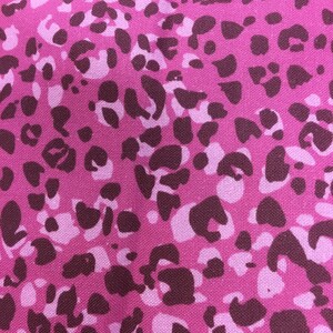 May include: Pink fabric with a brown leopard print pattern.