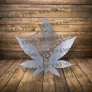 May include: A silver metal wall art piece depicting a marijuana leaf with a caduceus symbol in the centre. The caduceus is a symbol associated with medicine and healing.