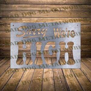 Puede incluir: Un letrero de metal con un acabado desgastado que dice "Lo siento, estamos altos".