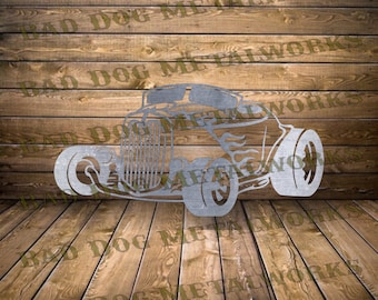 Könnte beinhalten: Ein Metallausschnitt eines Oldtimer-Hot-Rods mit Flammen an der Seite. Das Auto ist silberfarben und vor einem Holz Hintergrund platziert.