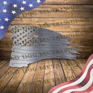 May include: A distressed American flag metal wall art with a weathered look. The flag is made of metal and has a rustic finish. The flag is hanging on a wooden wall. The text "Bad Dog Metalworks" is visible on the wall.