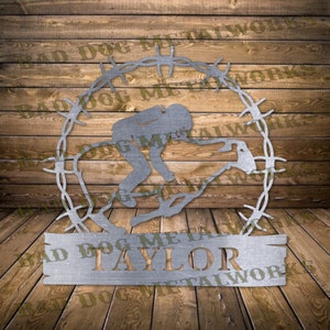 May include: Metal wall art featuring a silhouette of a person riding a bull, surrounded by barbed wire. The art includes the text "Bad Dog Metalworks" and a personalized name "Taylor".