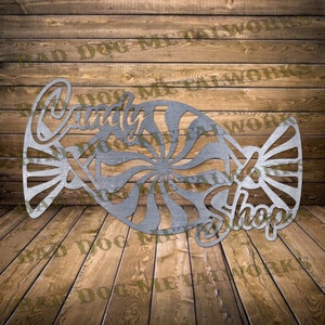 May include: Metal wall art in the shape of a candy cane with the words "Candy Shop" on it. The candy cane is silver and has a swirl design.