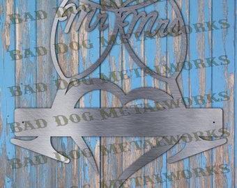 May include: Metal wedding sign with a heart and two glasses that say "Mr & Mrs". The sign is silver and has a rustic look.