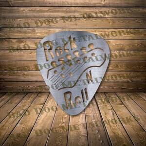 May include: A silver metal guitar pick with the words "Rock N Roll" and a silhouette of a guitar. The pick is on a wooden background.