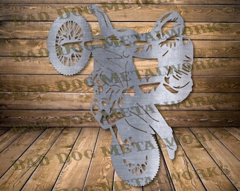 May include: A metal silhouette of a motocross rider performing a wheelie. The rider is in mid-air, with the front wheel of the motorcycle raised high. The silhouette is cut out of metal and has a brushed finish.
