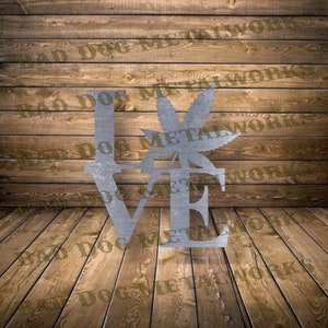 May include: Metal wall art sculpture of the word "LOVE" with a cannabis leaf in the centre. The sculpture is made of metal and has a rustic finish.