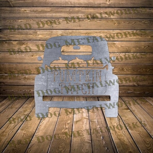 Könnte beinhalten: Ein Metallausschnitt eines Vintage-Pickups mit Kürbissen in der Ladefläche. Der LKW hat die Aufschrift "Pumpkin Patch" auf der Rückseite.