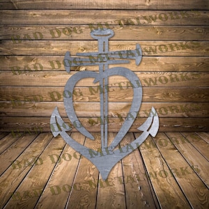 May include: A metal anchor design with a heart-shaped center. The anchor is silver-colored and has the words "BAD DOG METALWORKS" printed on the background. The anchor is set against a wooden plank background.