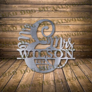 Może przedstawiać: Metalowy znak ślubny z ozdobnym wzorem w kształcie spirali i tekstem "Mr & Mrs Wilson Est. 2019".