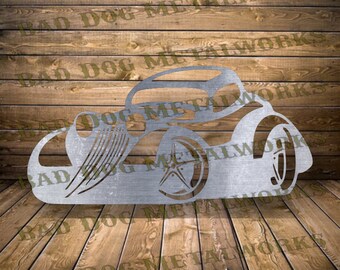 Könnte beinhalten: Ein Metallausschnitt eines Oldtimer-Hot-Rods. Das Auto ist silberfarben und hat ein detailliertes Design. Das Auto ist nach rechts gerichtet und hat ein großes Vorderrad.