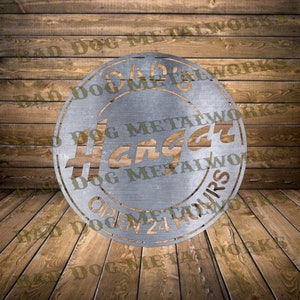 May include: A silver metal sign with the text "Dad's Hangar" and "Open 24 Hours" in a circle. The sign is made by Bad Dog Metalworks.