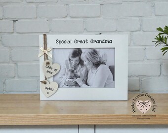 May include: White photo frame with the text "Special Great Grandma." Two wooden heart-shaped ornaments hang from the frame, one with "Lots of love" and the other with "Betsy x." The frame holds a black and white photo.