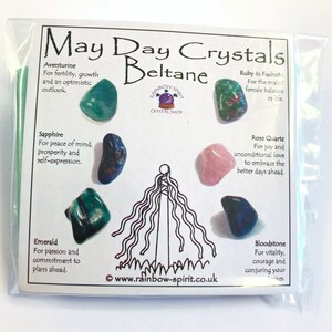 Pode incluir: Um pacote de pl&aacute;stico transparente contendo uma cole&ccedil;&atilde;o de cristais rotulados como "May Day Crystals Beltane". O pacote inclui v&aacute;rias pedras preciosas como Aventurina, Safira, Esmeralda, Quartzo Rosa e Pedra de Sangue, com descri&ccedil;&otilde;es.