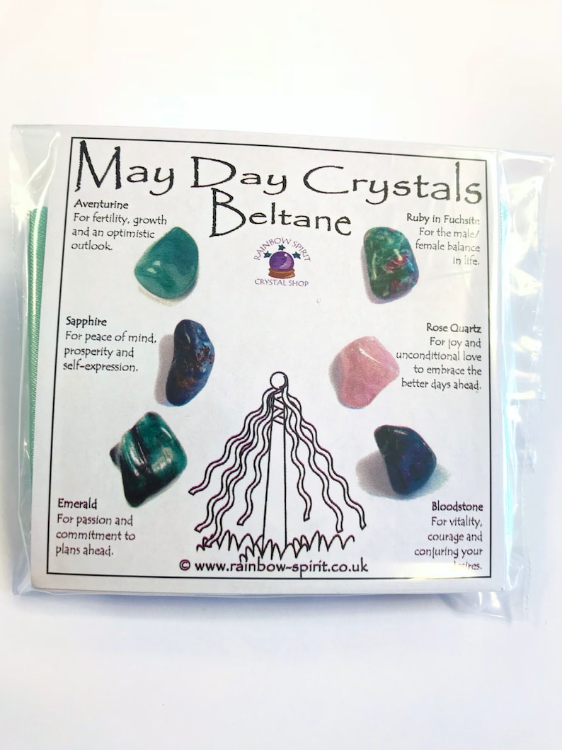 Pode incluir: Um pacote de pl&aacute;stico transparente contendo uma cole&ccedil;&atilde;o de cristais rotulados como "May Day Crystals Beltane". O pacote inclui v&aacute;rias pedras preciosas como Aventurina, Safira, Esmeralda, Quartzo Rosa e Pedra de Sangue, com descri&ccedil;&otilde;es.