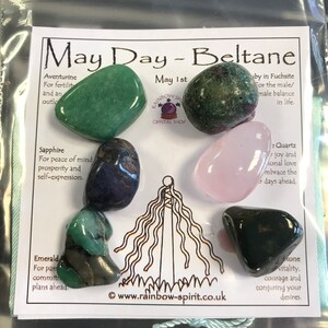 Pode incluir: Uma cole&ccedil;&atilde;o de pedras preciosas polidas, incluindo aventurina verde, rubi em fuchsita, quartzo rosa e obsidiana preta, dispostas em um cart&atilde;o. O cart&atilde;o diz "May Day - Beltane" e lista as propriedades de cada pedra.