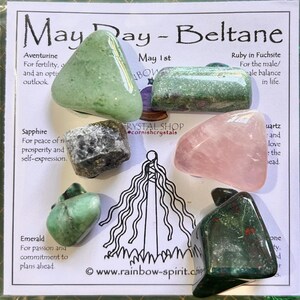 Pode incluir: Uma cole&ccedil;&atilde;o de pedras preciosas polidas, incluindo aventurina verde, rubi em fuchsita, safira, quartzo rosa, esmeralda e pedra de sangue, dispostas em um cart&atilde;o. O cart&atilde;o apresenta o texto "May Day - Beltane" e descri&ccedil;&otilde;es.