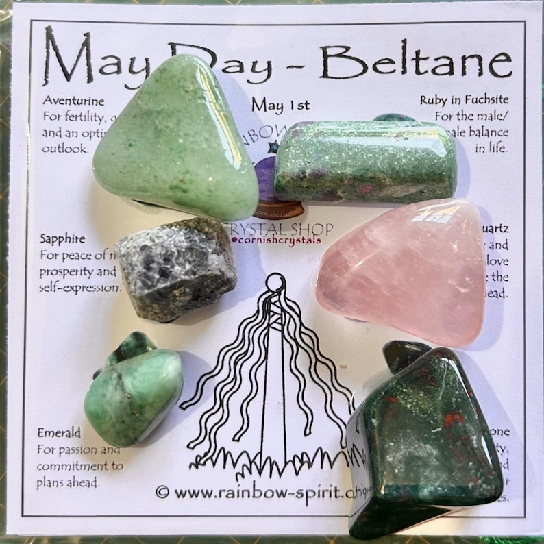 Pode incluir: Uma cole&ccedil;&atilde;o de pedras preciosas polidas, incluindo aventurina verde, rubi em fuchsita, safira, quartzo rosa, esmeralda e pedra de sangue, dispostas em um cart&atilde;o. O cart&atilde;o apresenta o texto "May Day - Beltane" e descri&ccedil;&otilde;es.