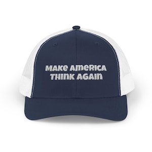 Könnte beinhalten: Marineblaue Trucker-Cap mit weißem Mesh-Rücken und gebogenem Schirm. Auf der Vorderseite steht der Text "MAKE AMERICA THINK AGAIN" in weißer Stickschrift. Ein lässiges Accessoire.