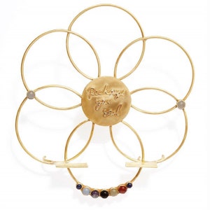 May include: Gold metal flower-shaped stand with a round center piece that says "Recharge your Soul". The stand has seven small stones around the outer edge.
