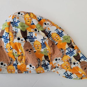 May include: A white, orange and blue Star Wars themed welding cap featuring a variety of characters including R2-D2, C-3PO, Yoda and Chewbacca.