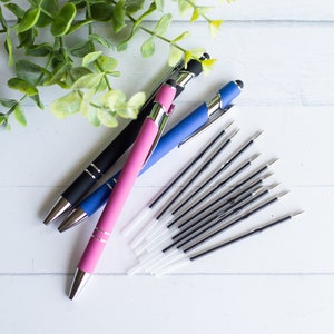 May include: Three pens with stylus tips, one black, one blue, and one pink, with a pile of black ink refills.