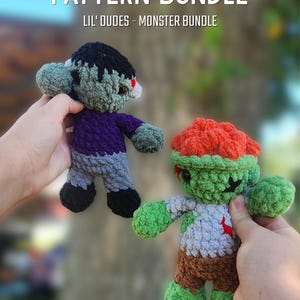 Może przedstawiać: Dwie szydełkowe lalki potwory z napisem PATTERN BUNDLE LIL' DUDES - MONSTER BUNDLE. Jedna lalka ma czarne włosy, fioletową koszulkę i szare spodnie. Druga ma pomarańczowe włosy, jasnoszarą koszulkę z czerwonym detalem i brązowe spodnie.