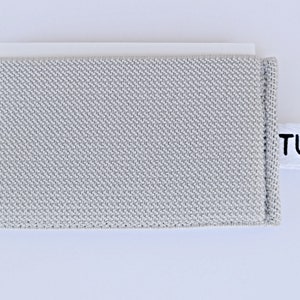 May include: A gray fabric card holder with a white label that says "TUQ".