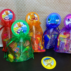May include: Four colorful organza bags filled with candy and bubble wands. Each bag has a round paper topper featuring a different character from the animated series "The Backyardigans".