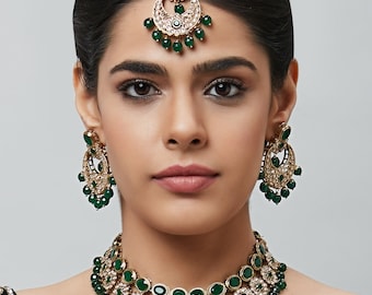 May include: A gold and green Indian bridal jewelry set with a necklace, earrings, and a maang tikka. The necklace features a layered design with green stones and white pearls. The earrings are similarly designed with green stones and white pearls. The maang tikka is a traditional Indian headpiece with a crescent moon design and green stones.