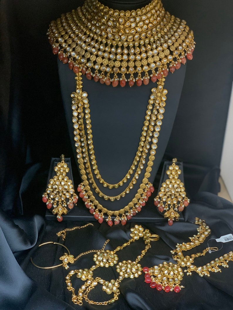 Kundan gold bridal jewelry set with red accentsIndian Etsy