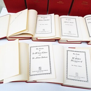 Pu&ograve; includere: Una collezione di libri in brossura rossa con scritte dorate sui dorsi. I libri sono disposti in una pila, con i titoli visibili. I titoli includono "Le Opere di Anton Čechov", "Le Opere di Alphonse Daudet", "Racconti di Natale di Charles Dickens", "Le Opere di Sir William Gilbert e Sir Arthur Sullivan", "Le Opere di H. Rider Haggard", e "Le Opere di Nathaniel Hawthorne".