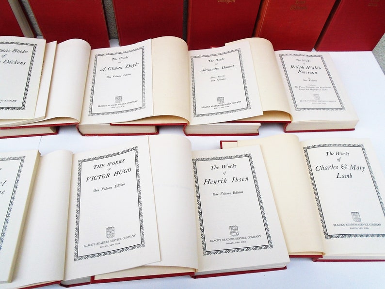 Pu&ograve; includere: Una collezione di libri in brossura rossa con titoli bianchi. I titoli includono "The Works of Charles Dickens", "The Works of A. Conan Doyle", "The Works of Alexandre Dumas", "The Works of Ralph Waldo Emerson", "The Works of Victor Hugo", "The Works of Henrik Ibsen" e "The Works of Charles & Mary Lamb".