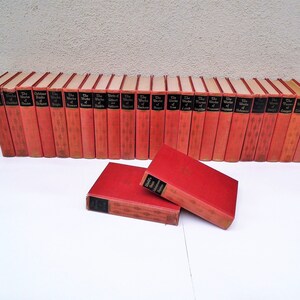 Pu&ograve; includere: Un set di 30 libri in brossura rossa con lettere dorate. I libri sono intitolati "The Works of Shakespeare".