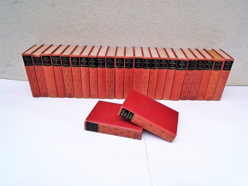 Pu&ograve; includere: Un set di 30 libri in brossura rossa con lettere dorate. I libri sono intitolati "The Works of Shakespeare".