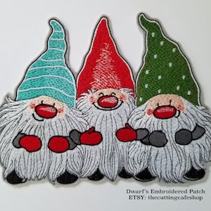 May include: Three embroidered gnomes with red, green, and blue hats. The gnomes are holding red mittens and are smiling. The gnomes are on a white background. Dwarf's Embroidered Patch ETSY: thecuttingcafeshop
