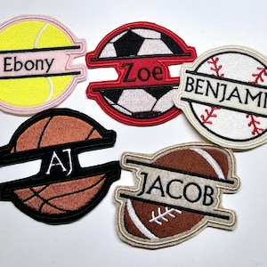 May include: Five embroidered patches featuring different sports balls with a name split in half by a black line. The patches are: tennis ball with "Ebony", soccer ball with "Zoe", baseball with "Benjamin", basketball with "AJ", and football with "Jacob".