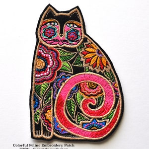 May include: Colorful embroidered patch of a black cat with a pink curled tail. The cat is surrounded by colorful flowers and leaves. The patch is perfect for adding a touch of whimsy to your clothing or accessories.