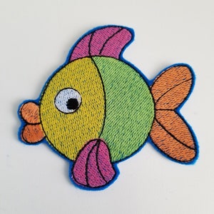 May include: A colorful embroidered fish patch with pink, green, yellow, and orange details. The fish has a large eye and a small mouth.