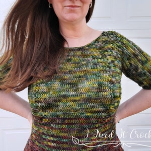 May include: A green, brown, and yellow crochet top with short sleeves. The top has a scoop neck and is made with a variegated yarn.