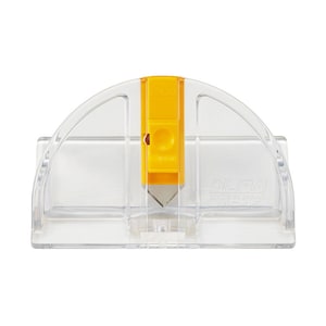 Puede incluir: Un cortador de círculos de plástico transparente con un mango amarillo y una cuchilla plateada. El cortador tiene el texto "OLFA® CIRCLE CUTTER" impreso en él.