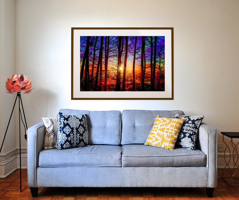 Puede incluir: Una impresi&oacute;n enmarcada de una puesta de sol colorida a trav&eacute;s de un bosque de &aacute;rboles. Los colores de la puesta de sol son rojo, naranja, amarillo, verde, azul y morado. Los &aacute;rboles est&aacute;n silueteados contra la puesta de sol.