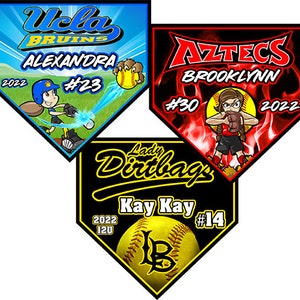 May include: Three baseball home plate signs with team names and player information. The top left sign is blue with the text "UCLA Bruins Alexandra #23 2022". The top right sign is red with the text "Aztecs Brooklynn #30 2022". The bottom sign is black with the text "Lady Dirtbags Kay Kay #14 2022 12U".