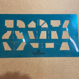 May include: A teal metal stencil with various geometric shapes cut out. The stencil includes curved and angled lines, and the text "SUTTON'S CUSTOM METAL ART" is printed on the bottom right.