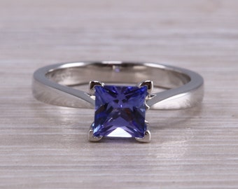 Puede incluir: Un anillo de plata con una piedra preciosa azul de forma cuadrada.