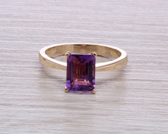 May include: A gold ring featuring a large, rectangular, purple amethyst gemstone.