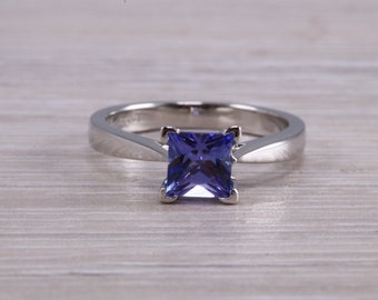 Puede incluir: Un anillo de plata con una piedra preciosa cuadrada de color azul oscuro.