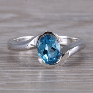 Oval cut Blue Topaz set Crossover Ring