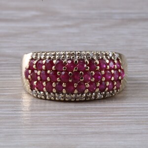 May include: A gold ring with a band of red rubies and small diamonds.